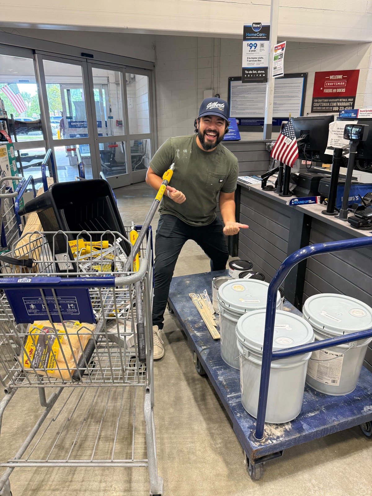 A volunteer with a cart of paint buckets on a supply run